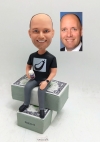 Custom bobblehead doll sitting on money